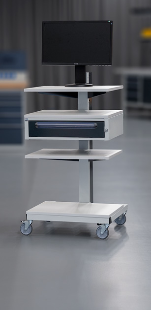 Mobiler Computerarbeitsplatz mit einem Monitor auf der obersten Ebene, Schublade in der Mitte und einer unteren Ablage, auf Rollen in einer industriellen Umgebung.